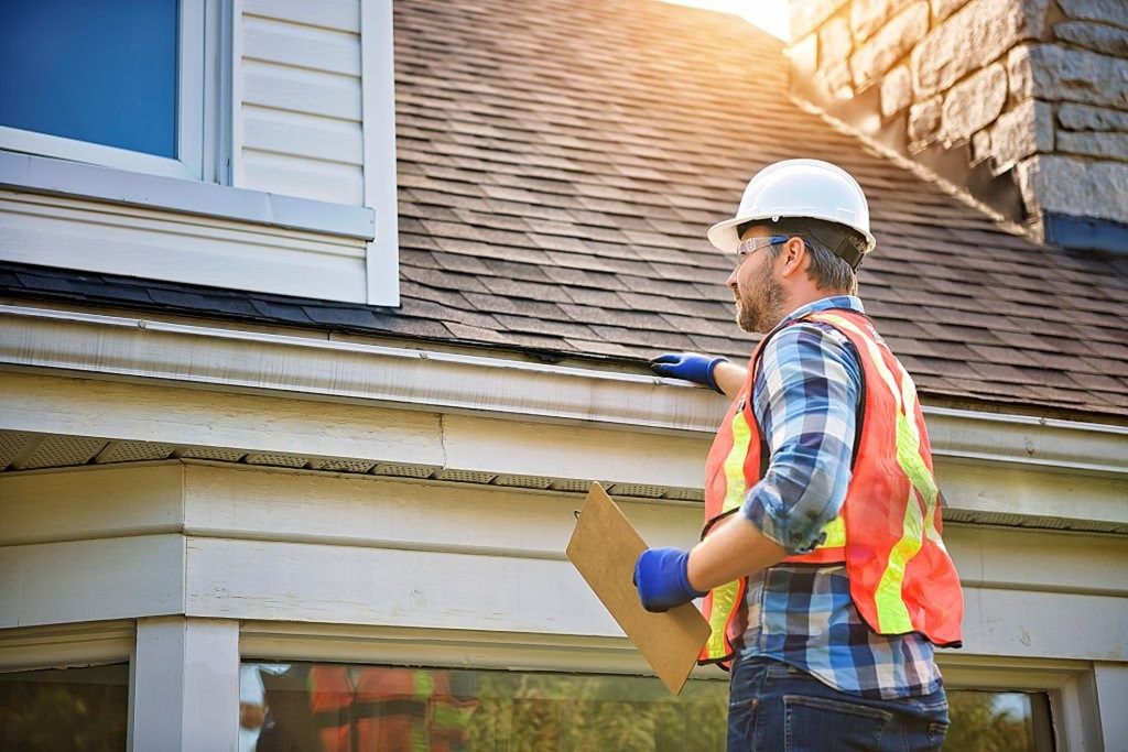 Roofing inspector examining the edge of a residential roof